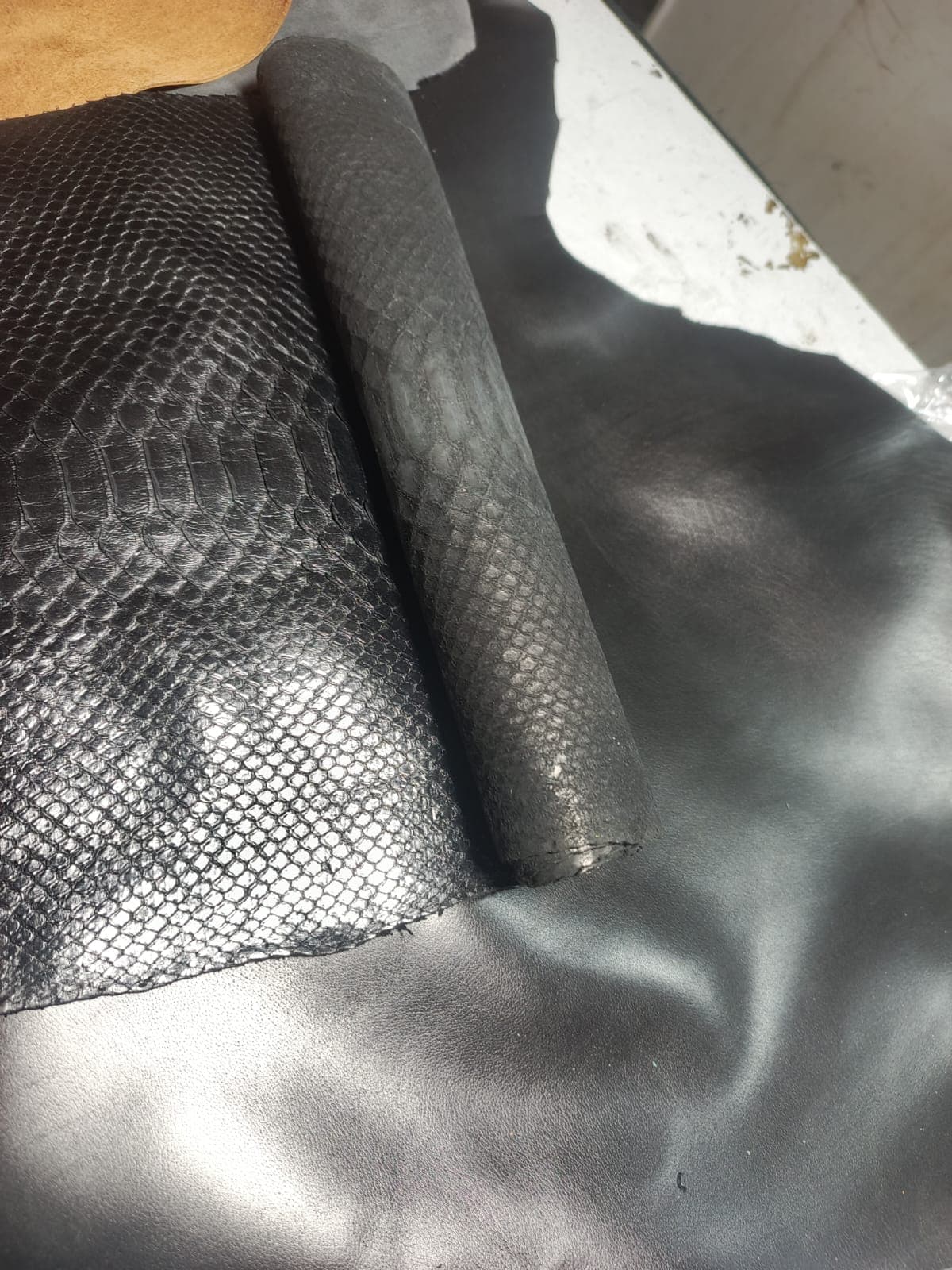 Rolls of snake-embossed leather on the material table