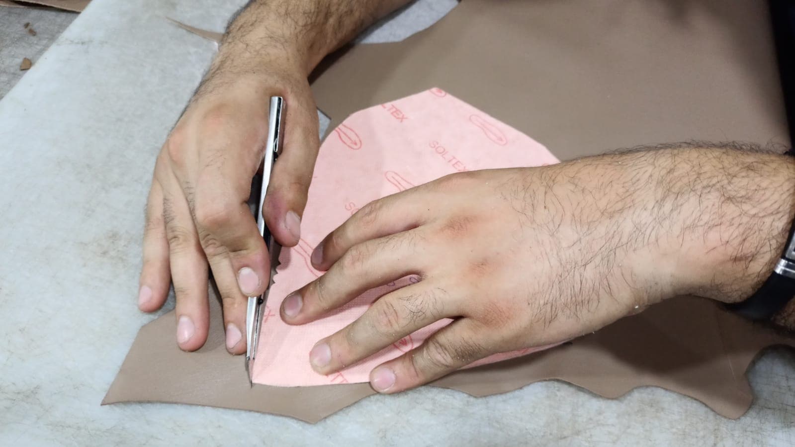 Cutting leather by hand around a pattern
